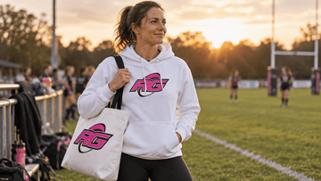 Woman in rugby sideline outfit for moms wearing RG Impact hoodie with tote by pitch