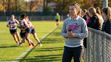Woman spectator in comfortable casual rugby sweatshirt watching matchside practice along the pitch fence