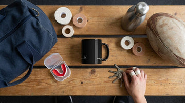 Essential rugby accessories including mug tape and gear organized for women players in clubhouse