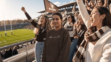 Female rugby supporters cheering in bleachers wearing stylish women's rugby supporter outfit ideas for game day