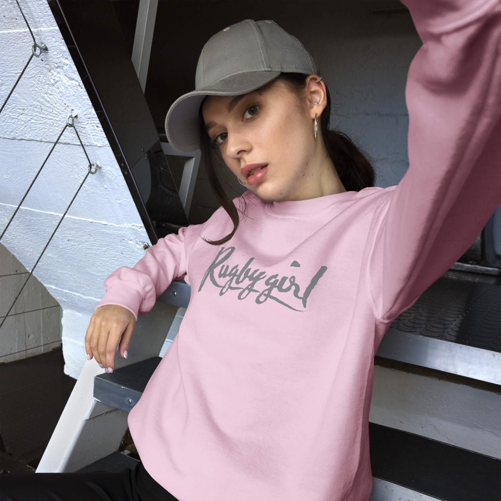 Light pink women's rugby sweatshirt with bold "Rugby Girl" script, casual rugby apparel style. - Rugby Girl
