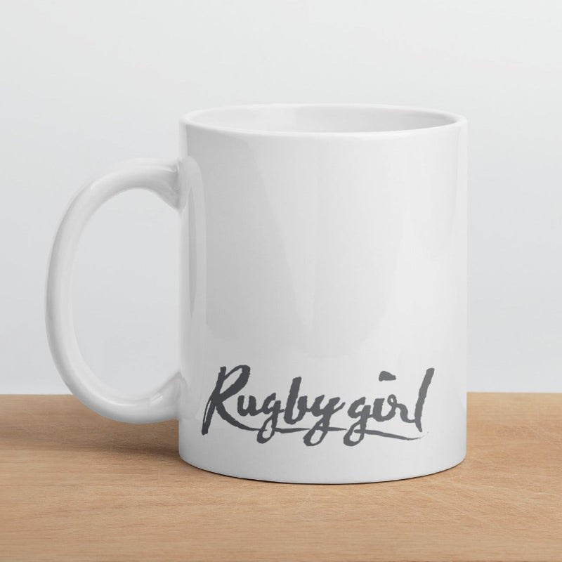 White ceramic mug with bold grey "Rugby girl" script, perfect rugby gift for fans and women's rugby apparel enthusiasts. - Rugby Girl