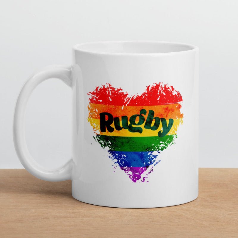 White ceramic mug with a rainbow heart and bold "Rugby" text, perfect rugby gift for rugby girl fans. - Rugby Girl